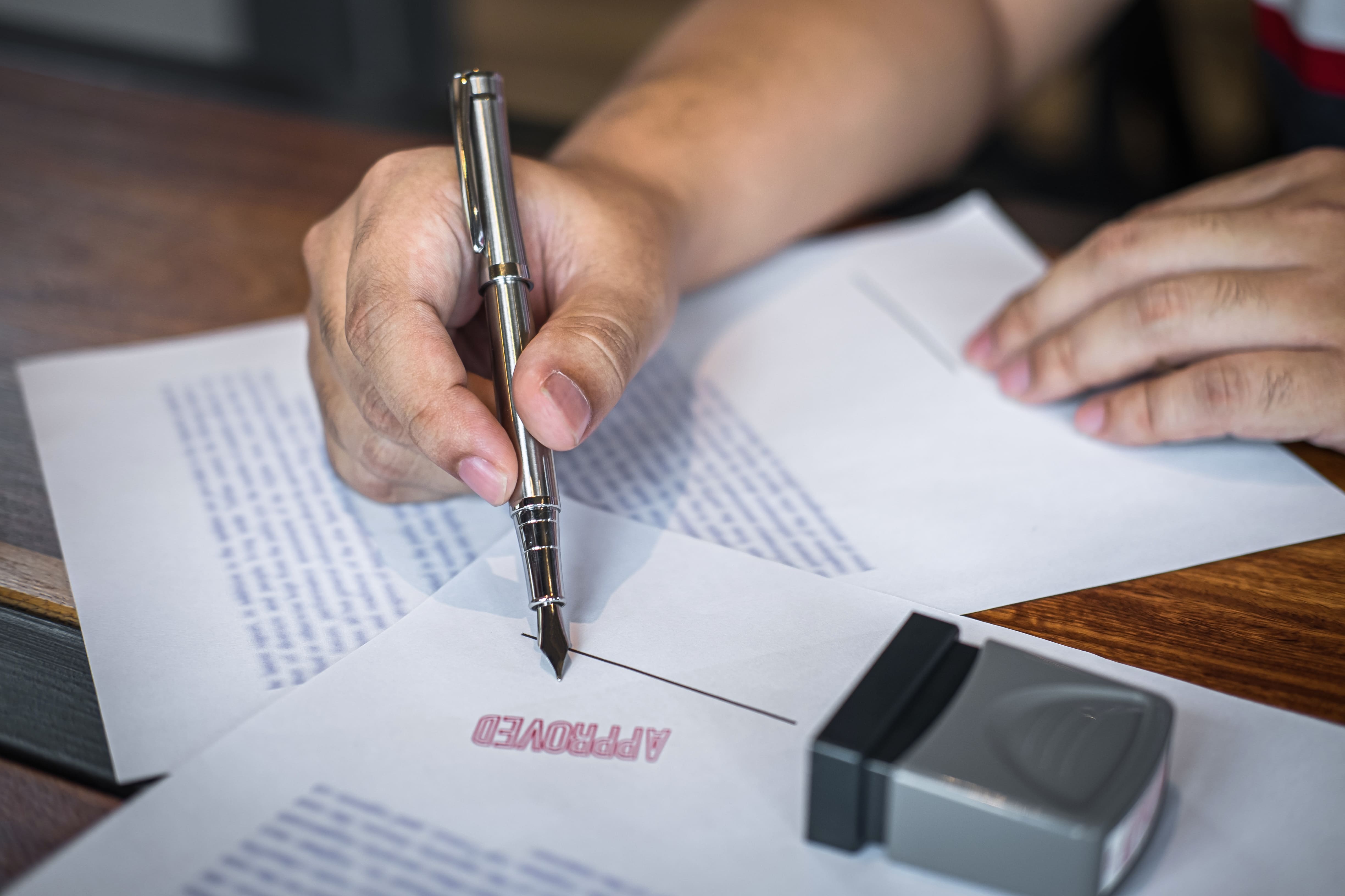 close-up-hands-of-businessman-signing-and-stamp-on-2023-11-27-05-14-36-utc-1-66fd4500cc5ac278257210.jpg